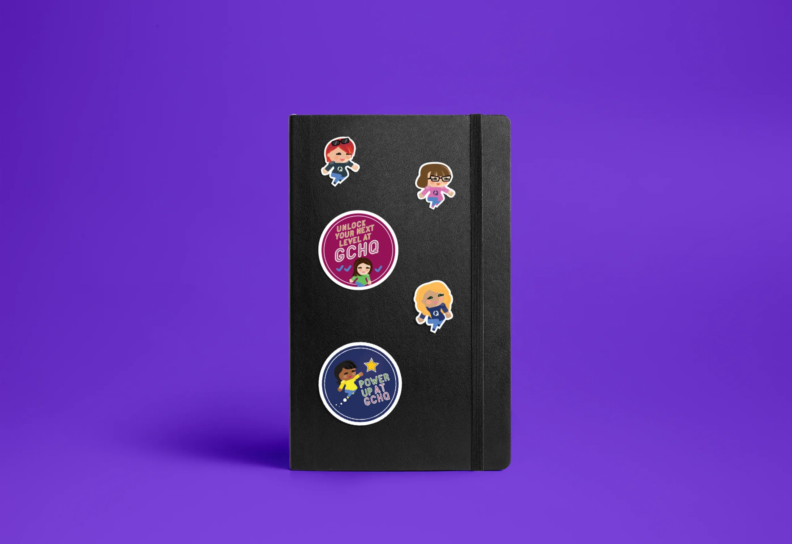 Image of notebook with 'Journey to GCHQ' sticker designs.