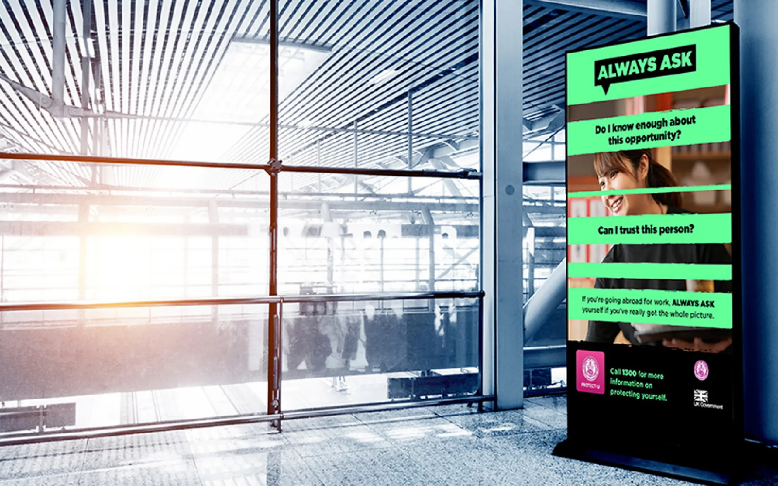 Image of campaign design displayed on digital screen in a public transport building.